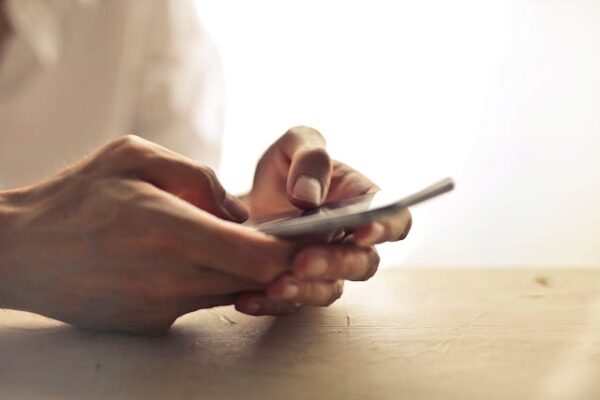Hands holding a mobile phone.